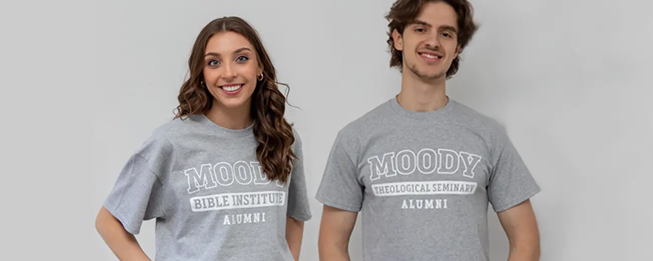 A man and a woman in gray Moody Bible shirts 